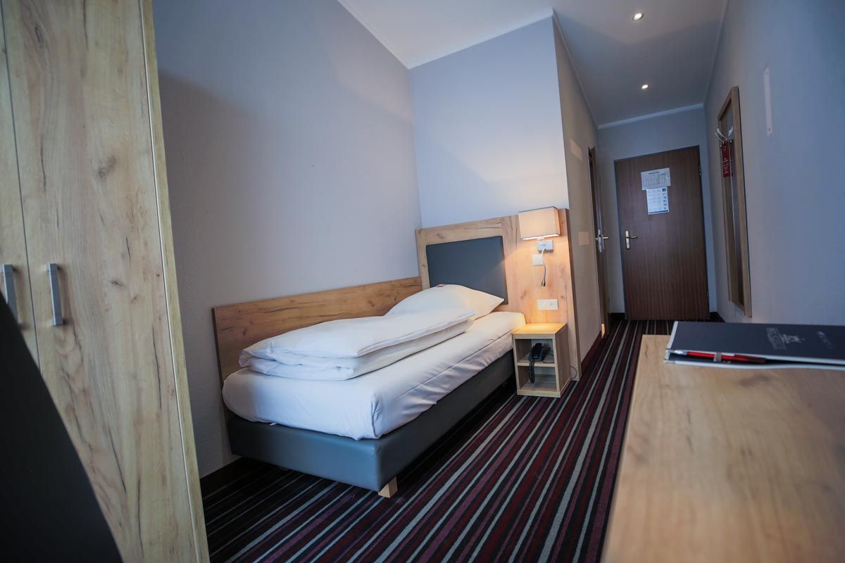 Zimmeransicht mit Bett und Eingang